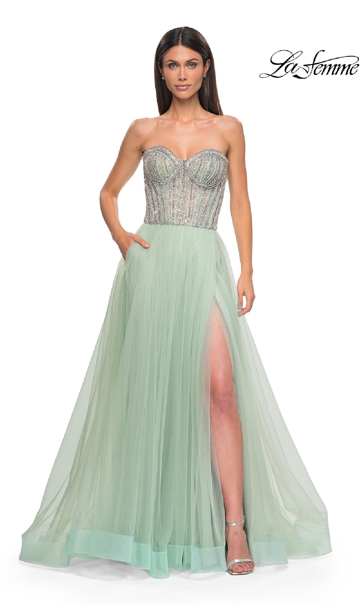 A woman poses against a plain white background wearing the La Femme 32811 Strapless Long Prom Ball Gown in mint green, featuring a beaded sweetheart corset bodice and high slit.